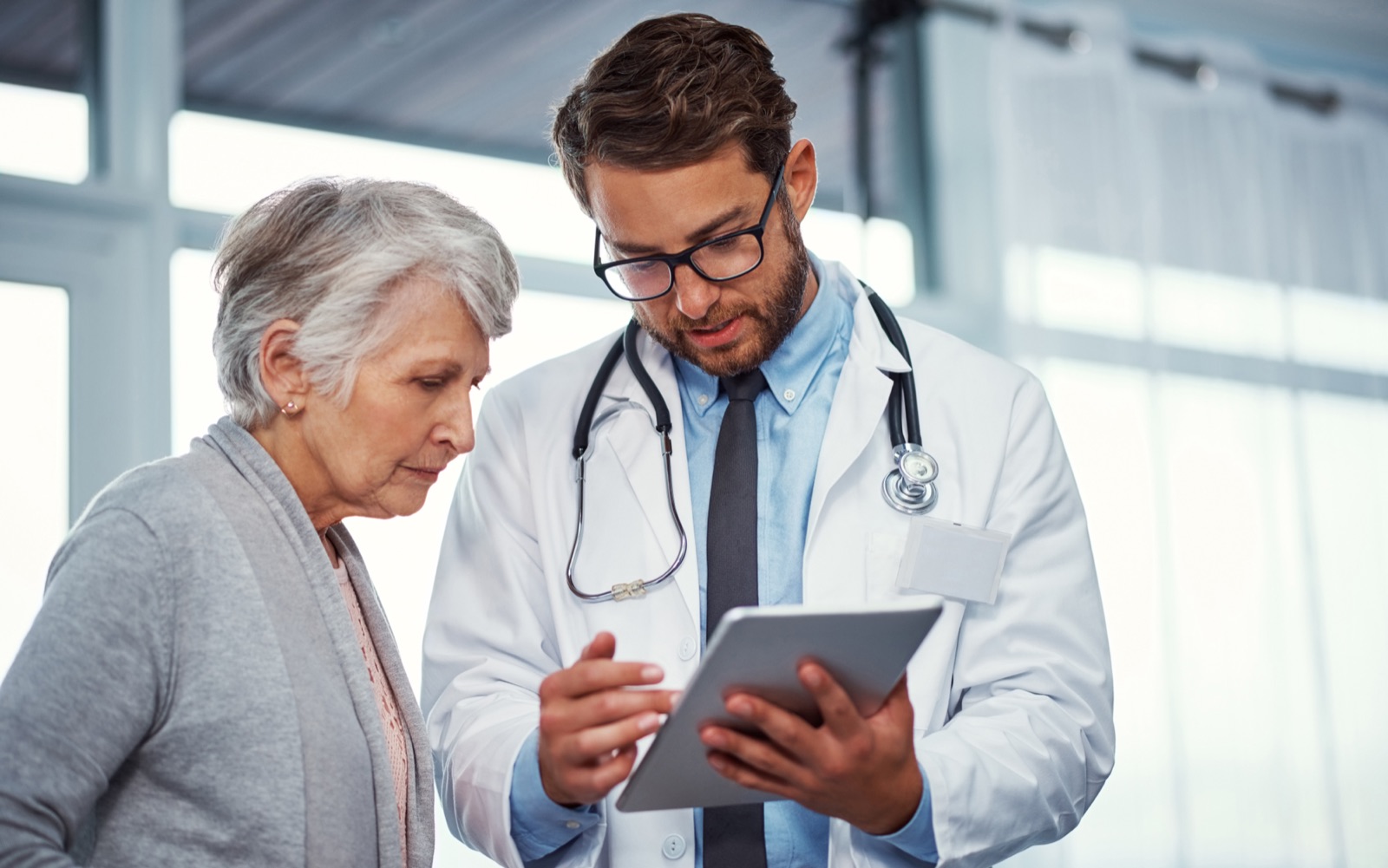Privatarzt bespricht Befunde mit Patientin am Tablet
